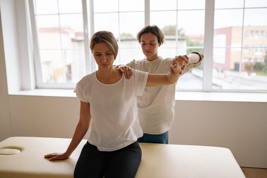 A therapist demonstrating a stretch to a client